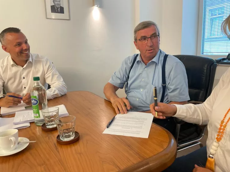Trois personnes signent un contrat