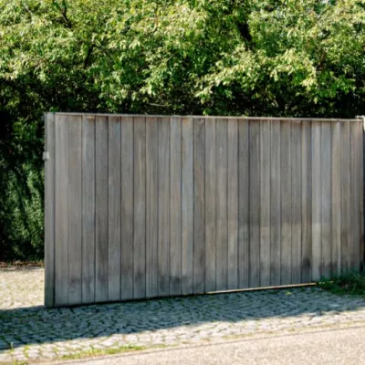 Un portail coulissant en bois avec un système d'interphone et de vidéo