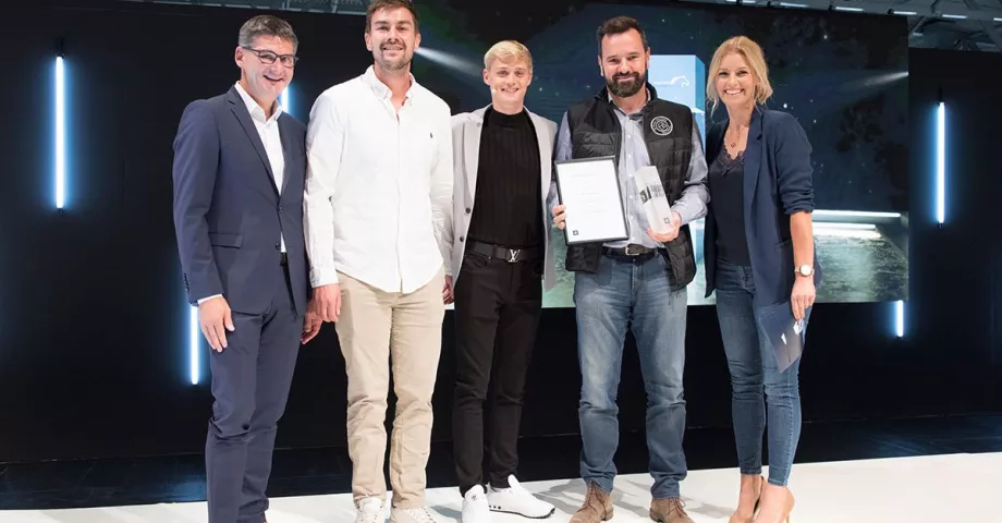 Un groupe de personnes se tenant côte à côte avec un trophée