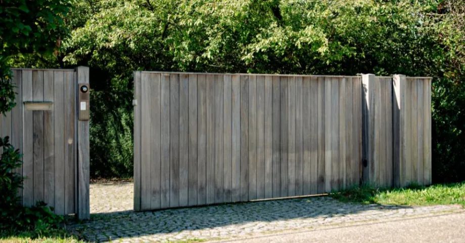 Un portail coulissant en bois avec un système d'interphone et de vidéo