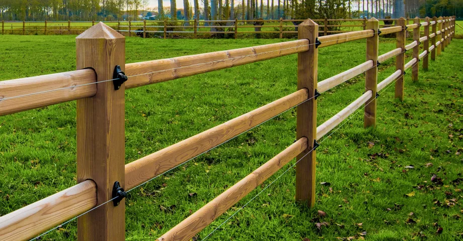 Une clôture avec des poteaux carrés dans lesquels les rails glissent.